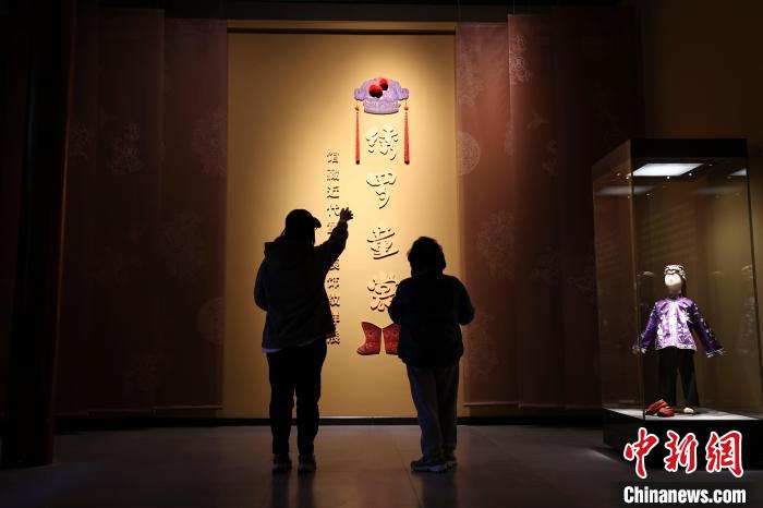 山西太原，民眾正在參觀《繡羅童裳——館藏近代童衣裝飾紋樣展》。　張?jiān)?攝