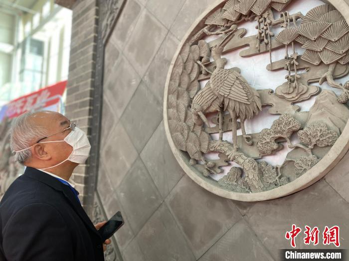 圖為2021邯鄲永年秋季房地產(chǎn)、家裝建材暨汽車博覽會上，一客戶在駐足觀看展出的磚雕產(chǎn)品。(資料圖) 趙明 攝