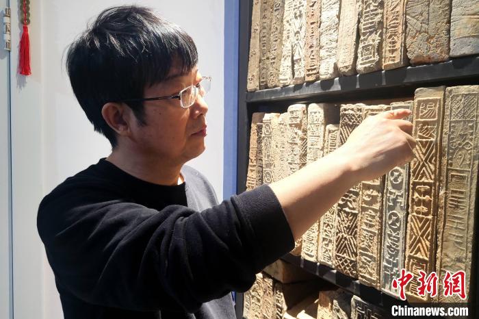 圖為謝濤講解古磚上的銘文?！「咪?攝