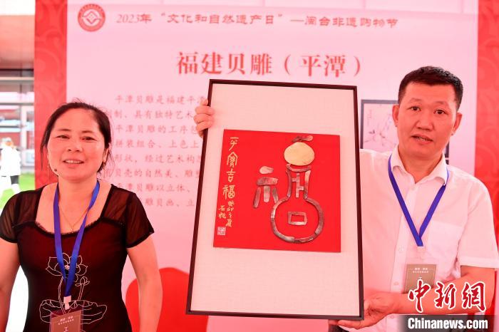 平潭貝雕非遺傳承人詹勝(右)，展示其與臺(tái)灣作家吳金城共同制作的貝雕作品“平安吉福”?！埥鸫?攝
