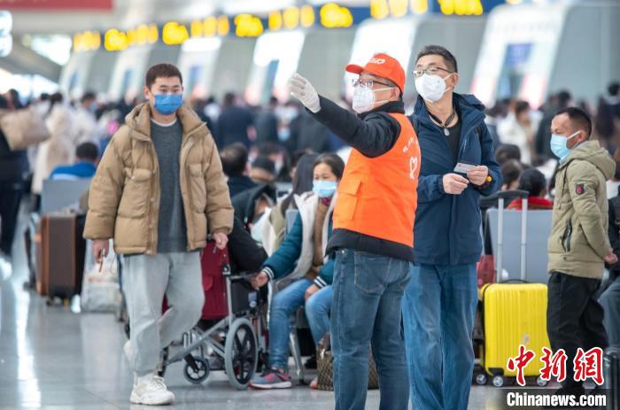 杭州東站鐵路志愿者為旅客指引檢票口方向。　曹志剛 攝