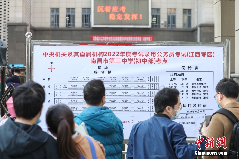 11月28日，江西南昌第三中學(xué)(初中部)考點，考生們在查看考場安排表。當(dāng)日，中央機(jī)關(guān)及其直屬機(jī)構(gòu)2022年度考試錄用公務(wù)員公共科目筆試舉行。<a target='_blank' href='/'>中新社</a>記者 劉力鑫 攝