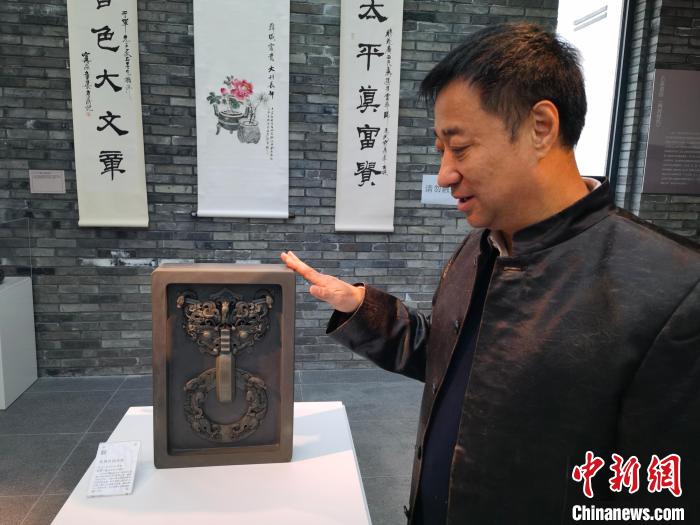 鄒洪利介紹根據(jù)易縣燕下都遺址出土的青銅器紋飾開發(fā)制作的龍鳳紋鋪首硯。　呂子豪 攝