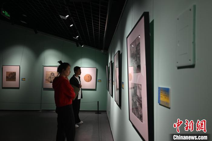 圖為市民在觀(guān)賞鋼筆畫(huà)作品?！埿?攝