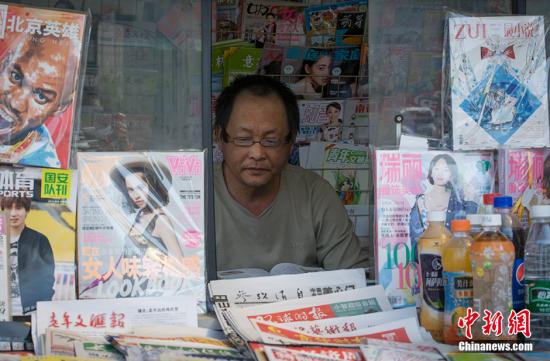北京，5燕師傅在報(bào)亭內(nèi)認(rèn)真的看書(shū)。<a target='_blank' href='/' >中新網(wǎng)</a>記者 翟璐 攝