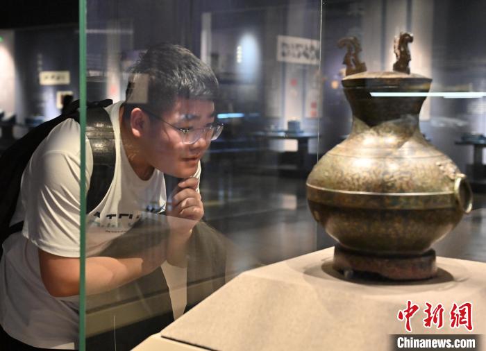 一名年輕人在吉林省博物院認(rèn)真觀看錯(cuò)金銀鳥(niǎo)篆文銅壺。　張瑤 攝