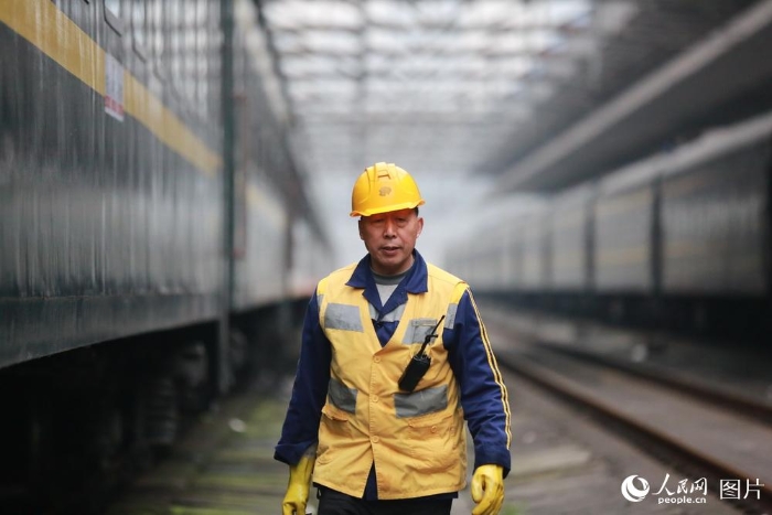 2月5日，在重慶北站站臺下，每當火車鳴笛進站時，幾位手拿鐵鑰匙、身穿黃馬褂的工人都會站在軌道邊等待。