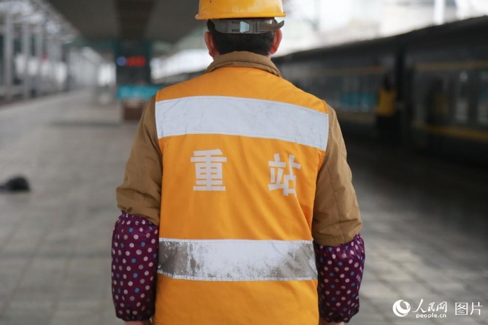 2月5日，在重慶北站站臺下，每當火車鳴笛進站時，幾位手拿鐵鑰匙、身穿黃馬褂的工人都會站在軌道邊等待。