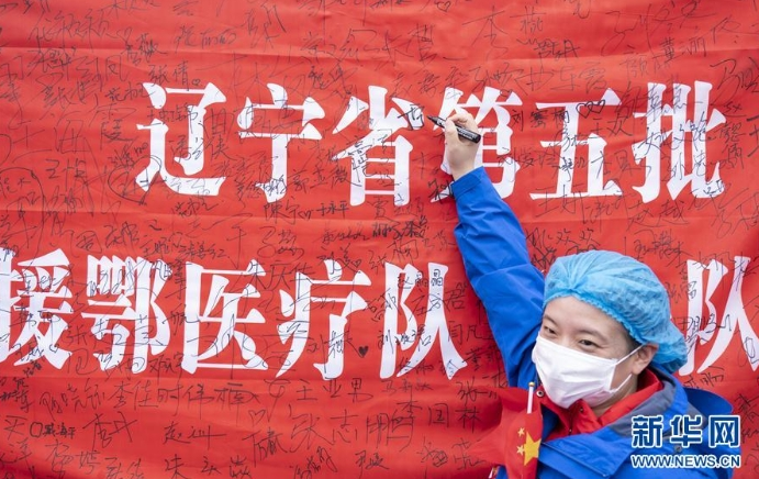3月29日，在武漢雷神山醫(yī)院舉行的集中撤離儀式上，醫(yī)護人員簽名留念。 當(dāng)日，武漢雷神山醫(yī)院舉行首批外省醫(yī)療隊集中撤離儀式，送別即將踏上歸途的遼寧、上海、吉林、廣東、山西、河北醫(yī)療隊的1090名醫(yī)護人員。 新華社記者 才揚 攝