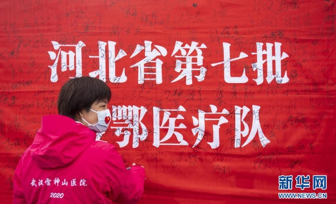 3月29日，在武漢雷神山醫(yī)院舉行的集中撤離儀式上，醫(yī)護人員簽名留念。 當(dāng)日，武漢雷神山醫(yī)院舉行首批外省醫(yī)療隊集中撤離儀式，送別即將踏上歸途的遼寧、上海、吉林、廣東、山西、河北醫(yī)療隊的1090名醫(yī)護人員。 新華社記者 才揚 攝