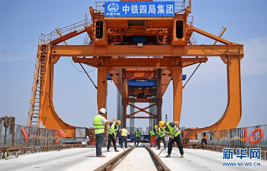5月2日，在安九高鐵江西段長(zhǎng)江特大橋施工現(xiàn)場(chǎng)，施工人員在進(jìn)行運(yùn)梁上橋作業(yè)。 “五一”假日期間，由中鐵四局承建的安（慶）九（江）高鐵江西段項(xiàng)目部對(duì)施工節(jié)點(diǎn)重新規(guī)劃，根據(jù)返崗人員工種相應(yīng)開展分項(xiàng)工程施工，加緊架橋建設(shè)，確保完成工程目標(biāo)。 新華社記者 萬(wàn)象 攝