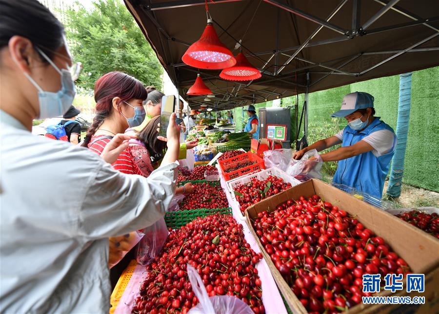 6月2日，在西安市曲江新區(qū)金滹沱二路，市民在臨時攤區(qū)選購食品。 近日，陜西省出臺《陜西省促進市場消費積極應(yīng)對新冠肺炎疫情影響若干措施》，在確保安全的情況下，允許城區(qū)臨街店鋪出店經(jīng)營，允許在居民居住集中區(qū)開辟臨時攤點攤區(qū)，允許流動商販在一定時間和區(qū)域占道經(jīng)營。 西安市曲江新區(qū)城市管理部門在做好疫情防控工作的前提下，在固定時間、固定區(qū)域開辟臨時攤點，積極推進“地攤經(jīng)濟”發(fā)展。 新華社記者 張博文 攝