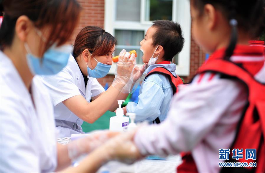 6月2日，成都市龍泉驛區(qū)明慧家美育幼兒園恢復(fù)開園，小朋友們在接受入園體檢。 當(dāng)日起，四川省成都市幼兒園按照分批分段、錯時錯峰的原則陸續(xù)開園。 新華社發(fā)（胥冰潔攝）
