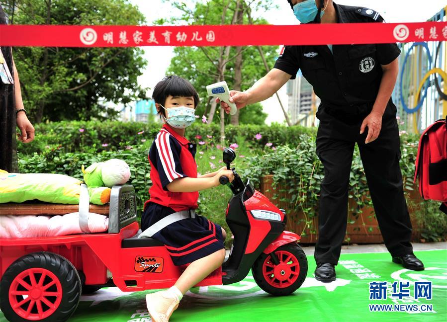 6月2日，成都市龍泉驛區(qū)明慧家美育幼兒園恢復(fù)開園，小朋友在測量體溫。 當(dāng)日起，四川省成都市幼兒園按照分批分段、錯時錯峰的原則陸續(xù)開園。 新華社發(fā)（胥冰潔攝）