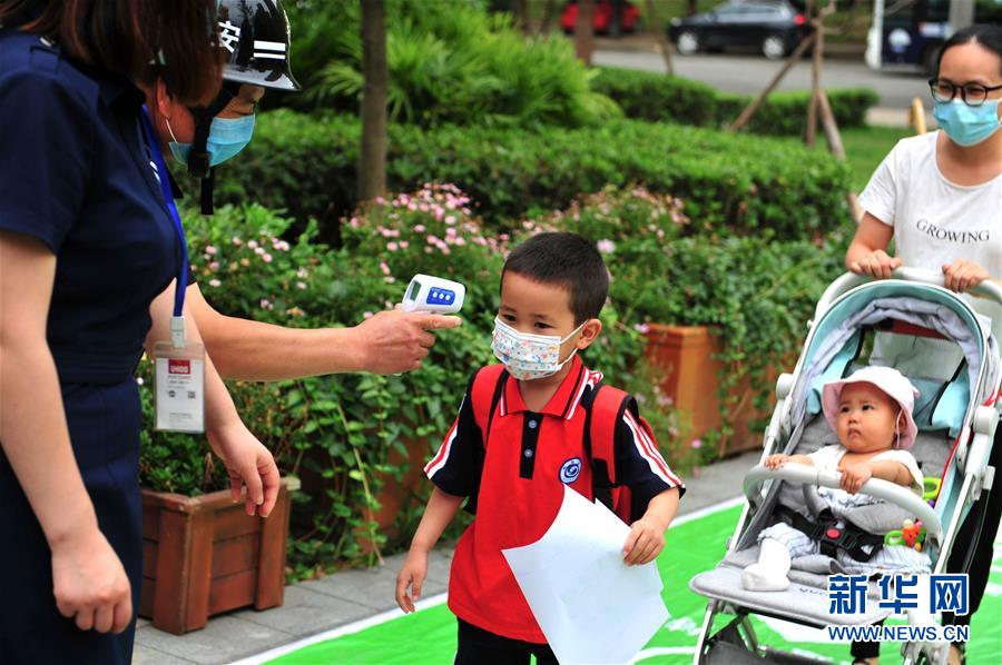 6月2日，成都市龍泉驛區(qū)明慧家美育幼兒園恢復(fù)開園，小朋友在測量體溫。 當(dāng)日起，四川省成都市幼兒園按照分批分段、錯時錯峰的原則陸續(xù)開園。 新華社發(fā)（胥冰潔攝）