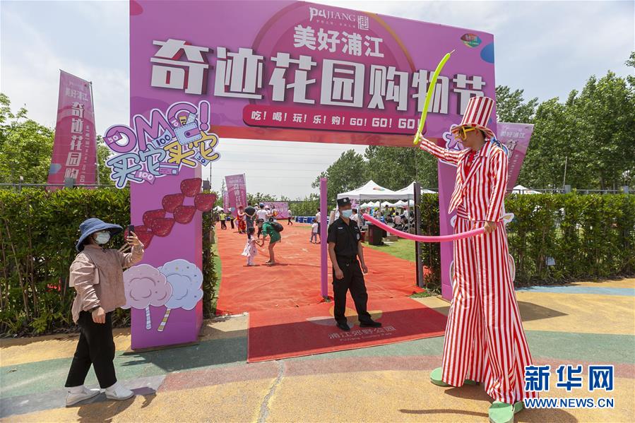 6月7日，打扮成高蹺小丑的藝人迎接前來參觀購物的市民。6月6日至7日，上海浦江郊野公園舉辦購物節(jié)，市民在公園游玩的同時，還能選購折扣商品。上海市閔行區(qū)浦江鎮(zhèn)整合區(qū)域市場資源，聯(lián)動優(yōu)質(zhì)品牌企業(yè)，舉辦郊野公園購物節(jié)。此次購物節(jié)融入線上直播帶貨新模式，旨在促進(jìn)地方企業(yè)復(fù)工復(fù)產(chǎn)，加快當(dāng)?shù)亟?jīng)濟(jì)復(fù)蘇，促進(jìn)消費回補(bǔ)。新華社發(fā)（王翔 攝）