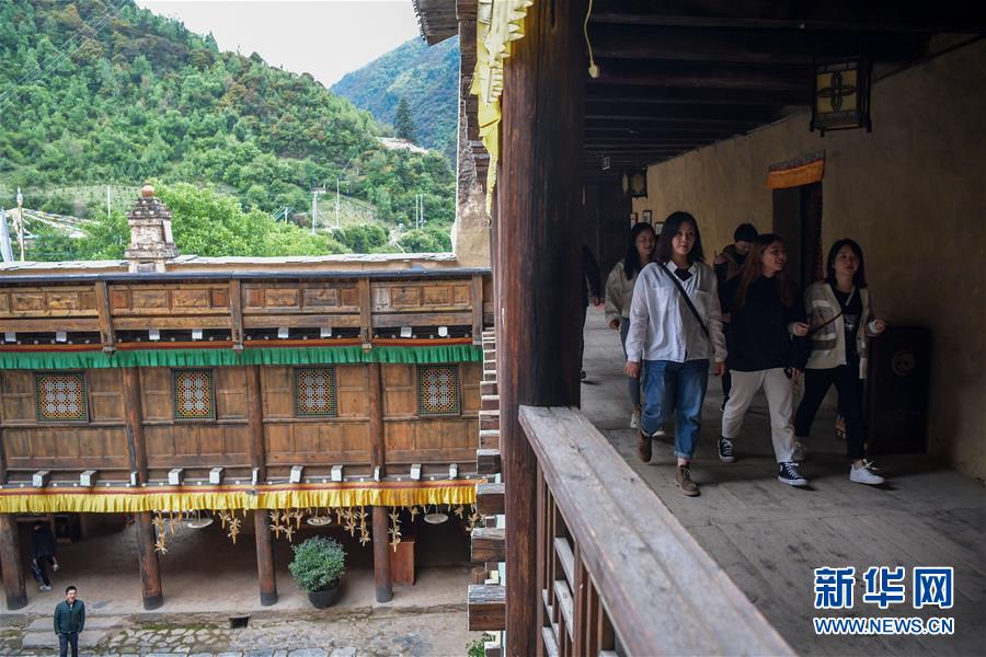 游客在卓克基土司官寨參觀（6月6日攝）。 坐落在四川省阿壩藏族羌族自治州馬爾康市的卓克基土司官寨規(guī)模龐大，構(gòu)造精細(xì)，總建筑面積5400平方米，建筑為仿四合院結(jié)構(gòu)，融合了藏漢建筑藝術(shù)精華。1935年紅軍長征途中的卓克基會(huì)議在此舉行。 新華社記者 高健鈞 攝