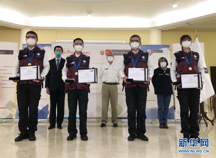 6月6日，在秘魯首都利馬衛(wèi)生部，中國援秘抗疫專家獲頒榮譽證書和獎?wù)潞笸佤斝l(wèi)生部長薩莫拉（中）合影。 秘魯衛(wèi)生部長薩莫拉6日晚在首都利馬代表秘魯政府向中國抗疫醫(yī)療專家組4名成員頒發(fā)榮譽證書和獎?wù)?，以表彰他們?yōu)槊佤斂挂吖ぷ魉鲐暙I。 新華社發(fā) （中國駐秘魯大使館供圖）