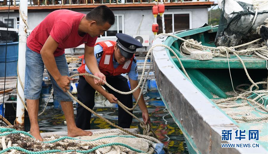 6月13日，海南省公安廳海岸警察總隊（籌備組）陵水支隊民警幫助轄區(qū)內(nèi)漁民固定漁船。 當(dāng)日，海南省氣象局于16時30分繼續(xù)發(fā)布臺風(fēng)四級預(yù)警。今年第2號臺風(fēng)“鸚鵡”（熱帶風(fēng)暴級）預(yù)計于14日在廣東沿海登陸。 新華社記者 楊冠宇 攝