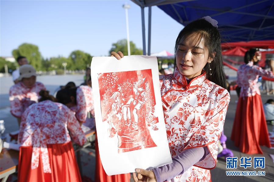 6月23日，一位剪紙參賽者展示自己的剪紙作品。 當日，全國最大的易地生態(tài)移民扶貧集中安置區(qū)寧夏吳忠市紅寺堡區(qū)舉行迎端午活動，邀請各鄉(xiāng)鎮(zhèn)的民間剪紙、刺繡藝人現(xiàn)場比拼傳統(tǒng)技藝，居民現(xiàn)場參與包粽子大賽，共迎端午節(jié)的到來。 新華社記者 王鵬 攝