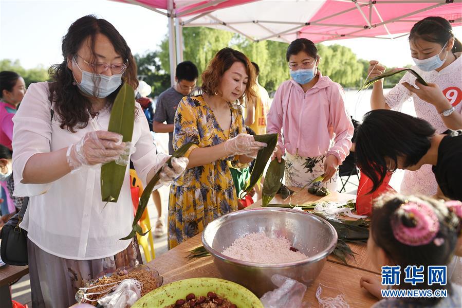 6月23日，居民在活動現(xiàn)場參加包粽子比賽。 當日，全國最大的易地生態(tài)移民扶貧集中安置區(qū)寧夏吳忠市紅寺堡區(qū)舉行迎端午活動，邀請各鄉(xiāng)鎮(zhèn)的民間剪紙、刺繡藝人現(xiàn)場比拼傳統(tǒng)技藝，居民現(xiàn)場參與包粽子大賽，共迎端午節(jié)的到來。 新華社記者 王鵬 攝