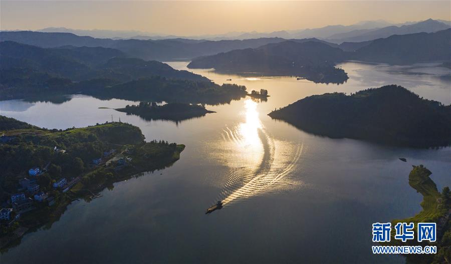 6月24日，一條船駛過(guò)夕陽(yáng)下的瀛湖湖面（無(wú)人機(jī)照片）。新華社記者 陶明 攝