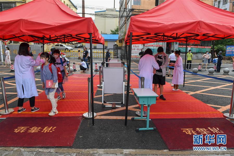 6月29日，在吉林市第一實驗小學，工作人員為學生測溫。當日，吉林省吉林市城區(qū)初中一、二年級，小學四至六年級復課。吉林市教育局要求各學校組織學生錯峰入校、放學、就餐和參加體育活動，確保校園疫情防控安全。 新華社記者 張楠 攝