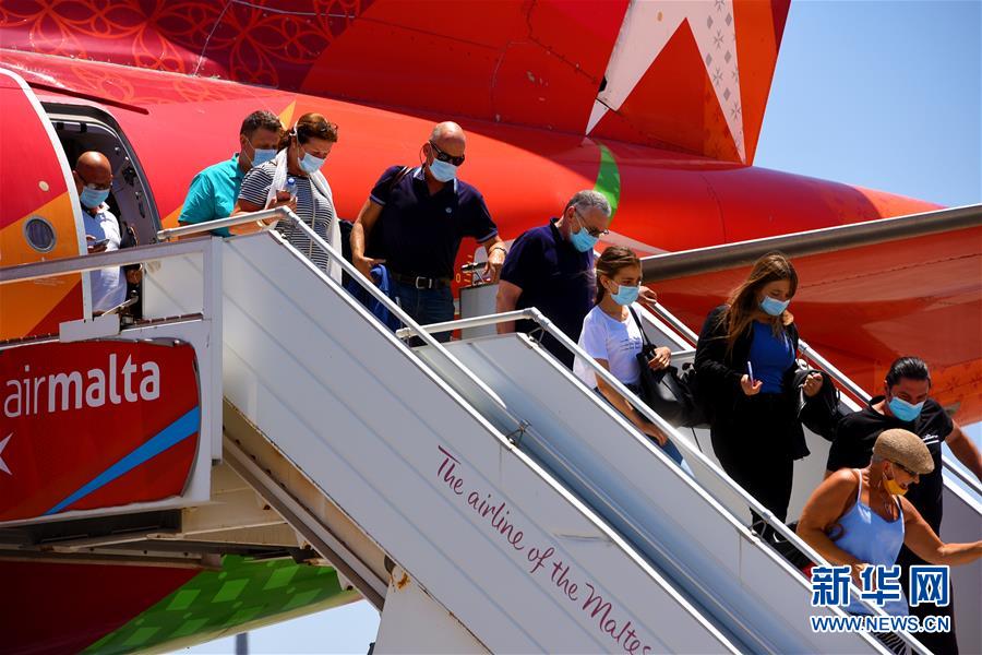 7月1日，在馬耳他國際機場，旅客走下飛機。 馬耳他國際機場于7月1日重新開放。 新華社發(fā)（喬納森·博爾格攝）