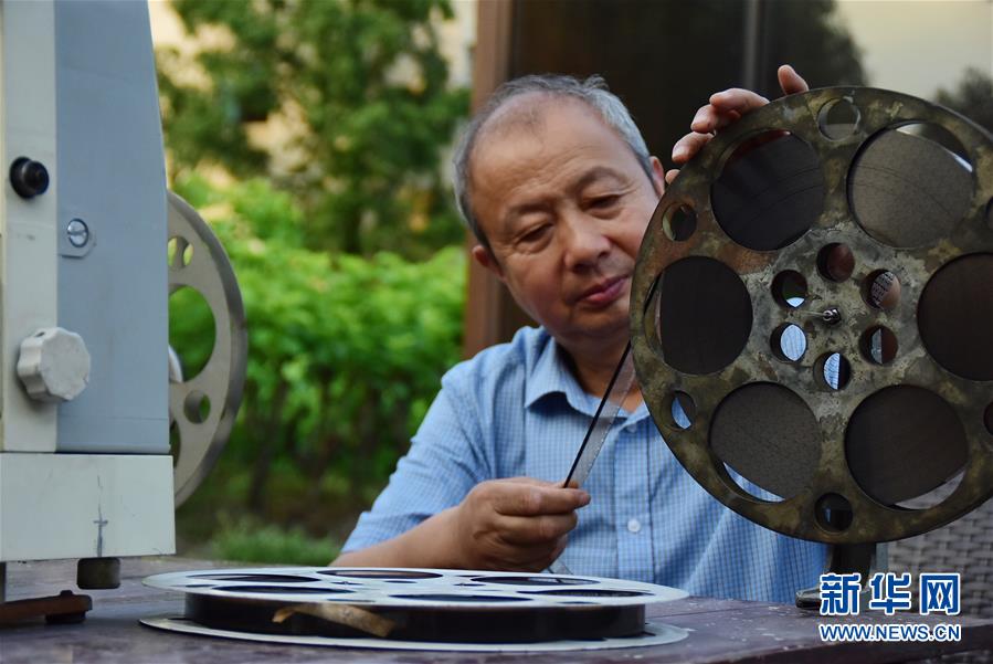 6月30日，朱生榮在當(dāng)晚電影開(kāi)播前將膠片調(diào)至起始幀。新華社記者 鄭夢(mèng)雨 攝