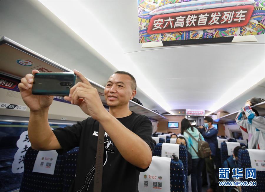 7月8日，在六盤水首發(fā)高鐵G2954次列車上，一名乘客拍照留念。 當日，安六高鐵（安順至六盤水）正式開通運營，貴州六盤水市全面接入全國高鐵網(wǎng)。 新華社記者 劉續(xù) 攝