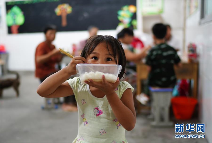 7月9日，小朋友在安置點里吃飯。 當日，江西鄱陽縣鄱陽鎮(zhèn)因洪水受災的村民被轉(zhuǎn)移到多個集中安置點。在鄱陽縣五一中心學校安置點，志愿者和工作人員接到任務后不到十小時內(nèi)，為被轉(zhuǎn)移村民布置了28間教室，供519人安頓，并為村民發(fā)放褥子、床單、枕頭、盒飯、飲用水等物資。 新華社記者 周密 攝