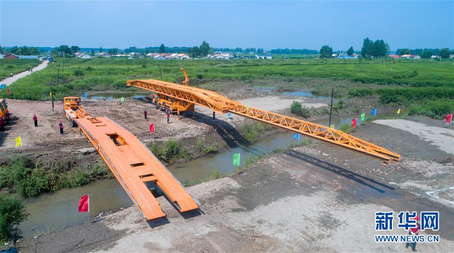 7月10日，工作人員在演練現(xiàn)場搭建機械化橋梁（無人機照片）。 當日，由吉林省交通運輸廳主辦的公路橋梁水毀搶通應(yīng)急演練在長春市雙陽區(qū)雙陽河舉行，參與演練人員從汛情水毀信息報送、應(yīng)急裝備快速集結(jié)、機械化橋梁搶通搭設(shè)、善后處理等方面進行實戰(zhàn)演練。 新華社記者 張楠 攝