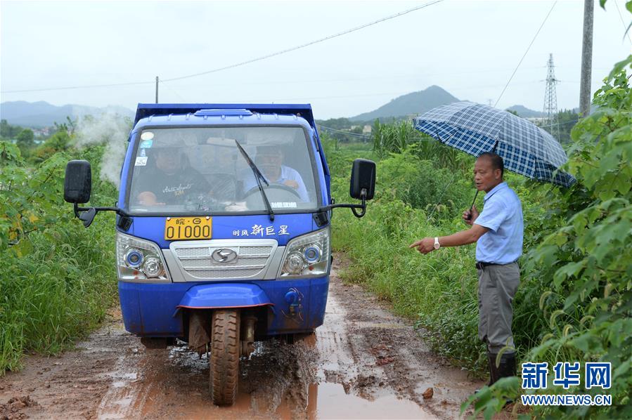 7月13日，張貴來（左三）和村民們一起將泥袋裝車。 新華社記者 黃博涵 攝