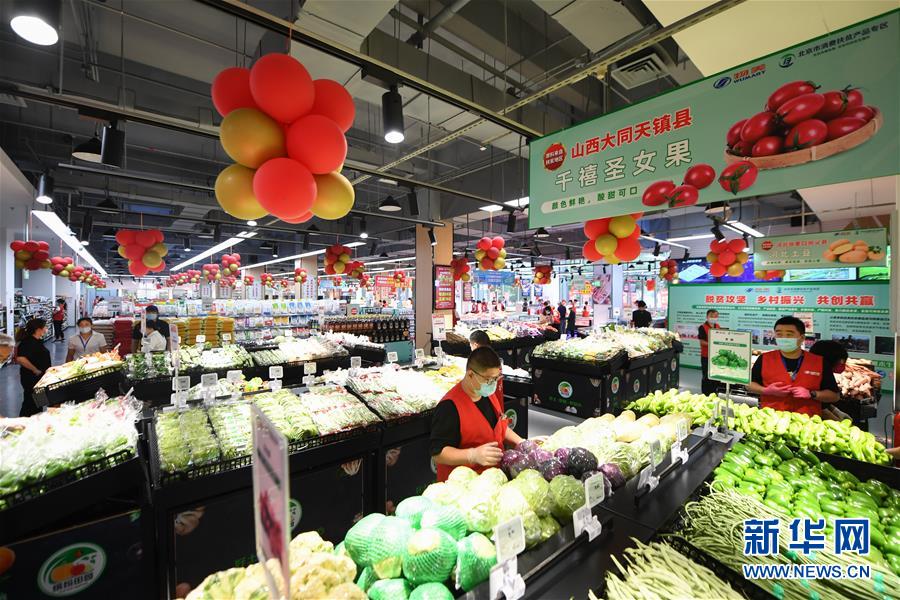 7月28日，工作人員在扶貧超市內(nèi)整理商品。 新華社記者 鞠煥宗 攝