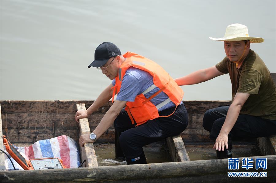 7月28日，在臨湘市聶市鎮(zhèn)毛灣垸，何繼善（左）查看檢測(cè)儀使用情況。新華社發(fā)（陳振海攝）