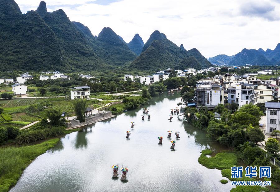 8月2日，在廣西桂林市陽朔縣，游人乘坐竹筏在遇龍河上游玩（無人機照片）。 新華社發(fā)（李斌 攝）