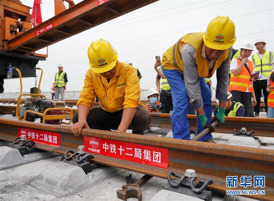 8月17日，中鐵十二局工人在進行鋪軌作業(yè)。 當日，京雄城際鐵路最后一組500米長鋼軌在河北雄安新區(qū)鋪設(shè)完成，標志著京雄城際鐵路全線軌道貫通。 新華社記者 牟宇 攝