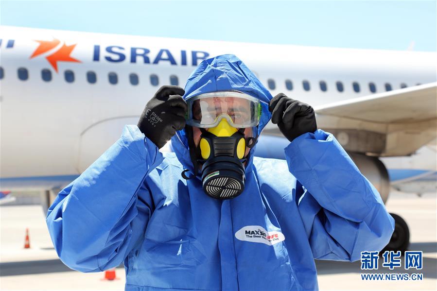 8月17日，一名工作人員在以色列本古里安國際機(jī)場(chǎng)的一架空客A320客機(jī)前穿戴防護(hù)設(shè)備。 新華社發(fā)（吉德翁攝）