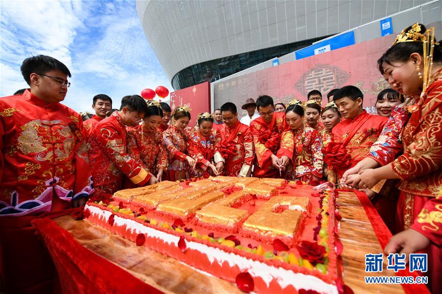 8月24日，在成都高新區(qū)體育中心項(xiàng)目建設(shè)現(xiàn)場(chǎng)，新人們一起切蛋糕。 當(dāng)日，一場(chǎng)以“建證幸福、喜迎大運(yùn)”為主題的中式傳統(tǒng)集體婚禮在成都高新區(qū)體育中心項(xiàng)目建設(shè)現(xiàn)場(chǎng)舉行，22對(duì)中建四局西南分局一線建設(shè)者喜結(jié)良緣。據(jù)悉，由于眾多建設(shè)者常年忙碌在施工一線，不少領(lǐng)取結(jié)婚證的夫婦沒有時(shí)間舉辦婚禮。在七夕節(jié)來臨之際，中建四局西南分局特意為他們舉辦集體婚禮。 新華社記者 王曦 攝
