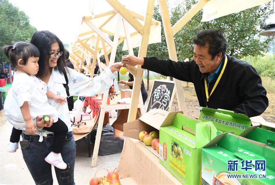 9月24日，市民在平谷特色農(nóng)產(chǎn)品展示區(qū)了解農(nóng)產(chǎn)品。 當(dāng)日，北京市平谷區(qū)2020年中國農(nóng)民豐收節(jié)活動在平谷區(qū)馬昌營鎮(zhèn)開幕。本次活動以“慶豐收 迎小康”為主題，包括歐李節(jié)、紅薯節(jié)、大華山鎮(zhèn)級農(nóng)民豐收節(jié)等。 新華社記者 任超 攝