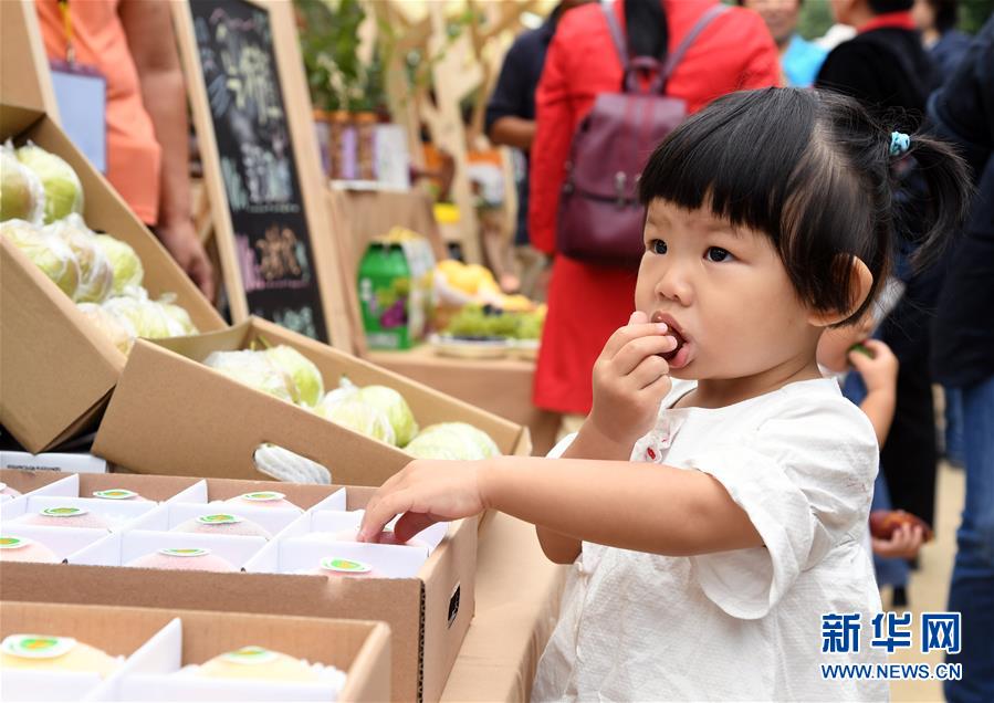 9月24日，在平谷特色農(nóng)產(chǎn)品展示區(qū)，一名小朋友品嘗農(nóng)產(chǎn)品。 當(dāng)日，北京市平谷區(qū)2020年中國農(nóng)民豐收節(jié)活動在平谷區(qū)馬昌營鎮(zhèn)開幕。本次活動以“慶豐收 迎小康”為主題，包括歐李節(jié)、紅薯節(jié)、大華山鎮(zhèn)級農(nóng)民豐收節(jié)等。 新華社記者 任超 攝