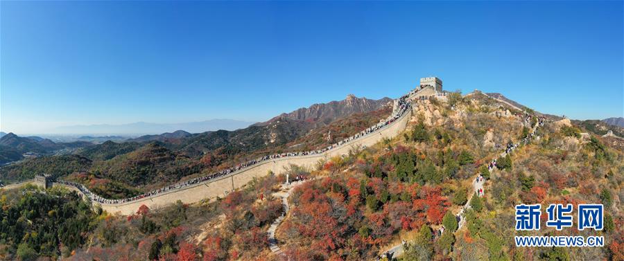 10月24日，游人在八達(dá)嶺長城游覽（無人機全景照片）。 深秋時節(jié)，北京八達(dá)嶺長城紅葉進(jìn)入最佳觀賞期，紅葉映長城美如畫卷。 新華社記者 陳曄華 攝