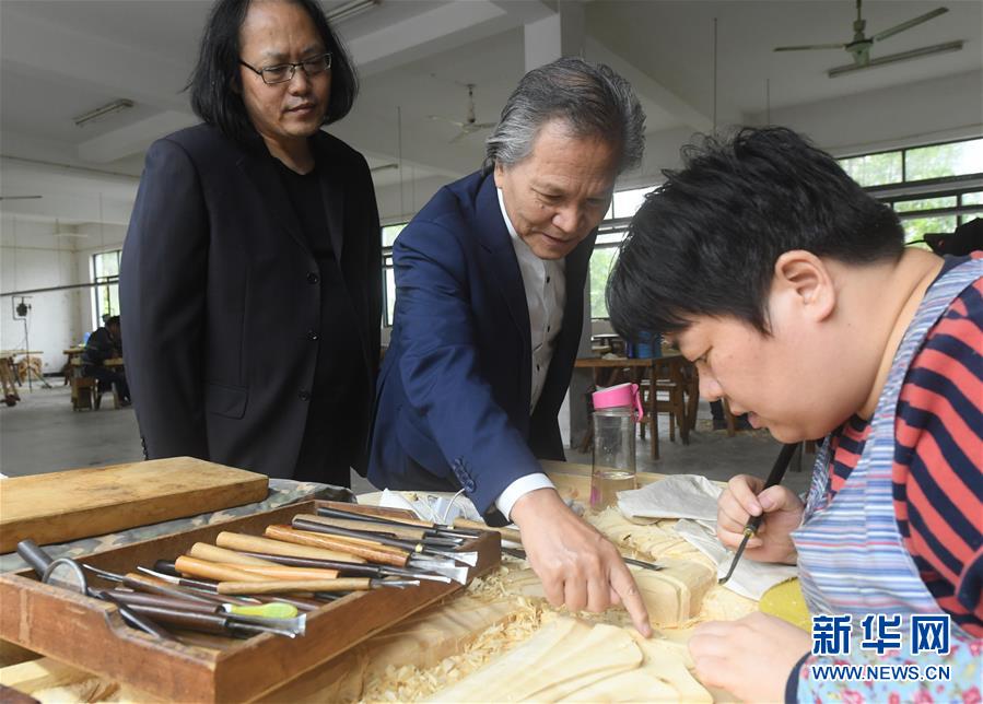 亞太地區(qū)手工藝大師、中國工藝美術(shù)大師陸光正（中）在其創(chuàng)作室內(nèi)和工作人員交流雕刻細(xì)節(jié)（10月19日攝）。新華社記者 翁忻旸 攝