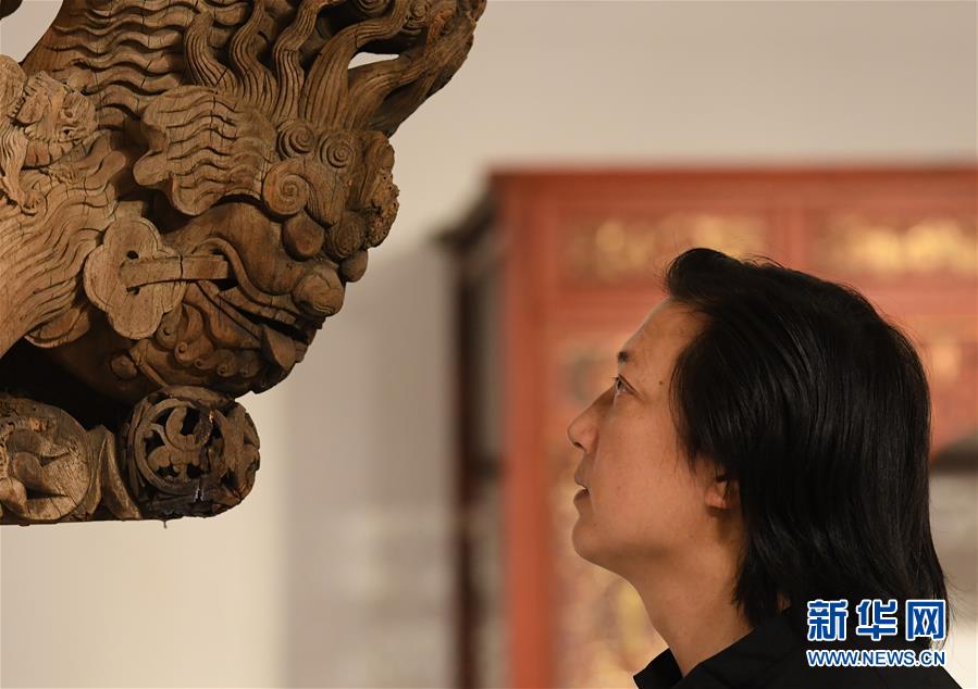 浙江省工藝美術(shù)大師陳國華在工作室觀察收藏的老木雕建筑構(gòu)件的細(xì)節(jié)（10月20日攝）。 新華社記者 翁忻旸 攝