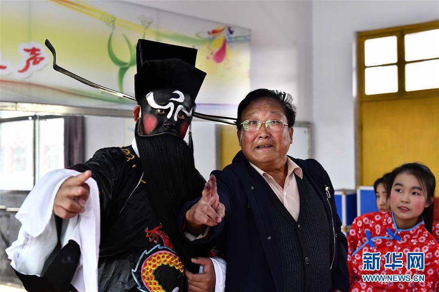 10月28日，在棗莊市臺兒莊區(qū)西關(guān)小學(xué)，文藝志愿者馬永法（中）在指導(dǎo)小學(xué)員。新華社記者 郭緒雷 攝