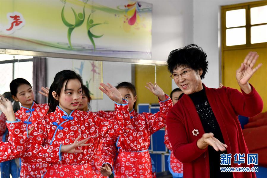 10月28日，在棗莊市臺兒莊區(qū)西關(guān)小學(xué)，文藝志愿者張鳳云在指導(dǎo)小學(xué)員練身段。新華社記者 郭緒雷 攝
