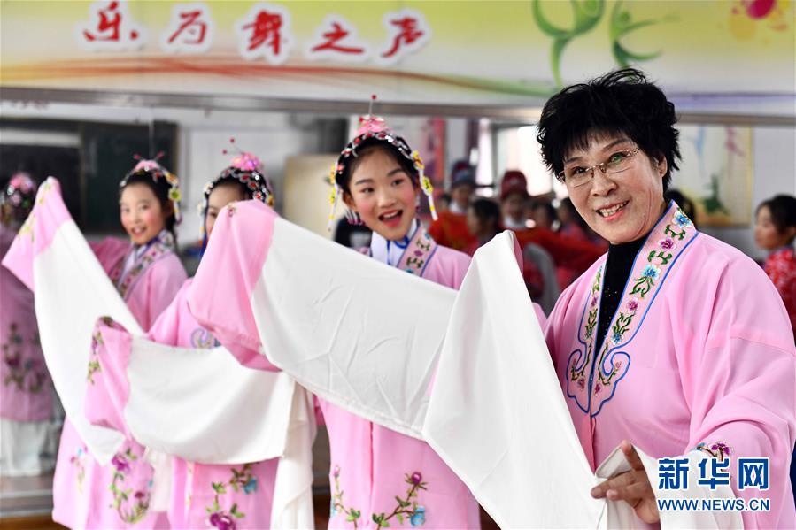 10月28日，在棗莊市臺兒莊區(qū)西關(guān)小學(xué)，文藝志愿者張鳳云在指導(dǎo)小學(xué)員練身段。新華社記者 郭緒雷 攝