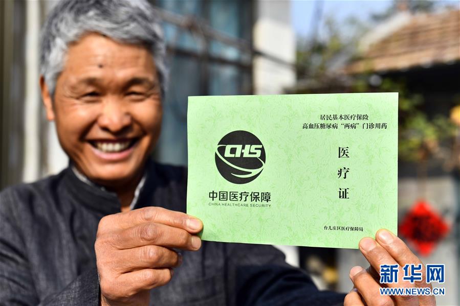 10月29日，在棗莊市臺(tái)兒莊區(qū)澗頭集鎮(zhèn)旺莊村，村民王明洋展示自己的高血壓糖尿病“兩病”門診用藥醫(yī)療證。 2020年9月，山東省棗莊市臺(tái)兒莊區(qū)實(shí)施高血壓、糖尿病“兩病”醫(yī)保報(bào)銷政策下沉，將醫(yī)保報(bào)銷由鎮(zhèn)級(jí)衛(wèi)生院延伸到村級(jí)衛(wèi)生室，并組織家庭醫(yī)生為行動(dòng)不便的“兩病”群眾送醫(yī)送藥，讓群眾在家門口就享受到醫(yī)改政策紅利。 新華社記者 郭緒雷 攝