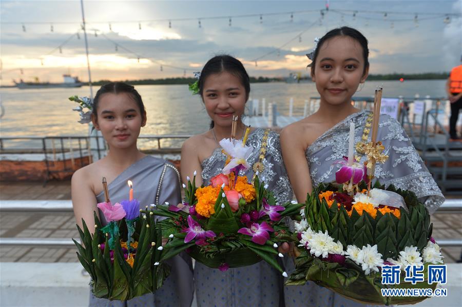 10月31日，身穿泰國(guó)傳統(tǒng)服飾的女孩在曼谷湄南河邊展示她們的水燈。當(dāng)日是泰國(guó)傳統(tǒng)節(jié)日水燈節(jié)，泰國(guó)各地民眾前往河流或湖泊沿岸施放水燈，祈求流水帶走厄運(yùn)，未來(lái)幸福如意。新華社發(fā)（拉亨攝）