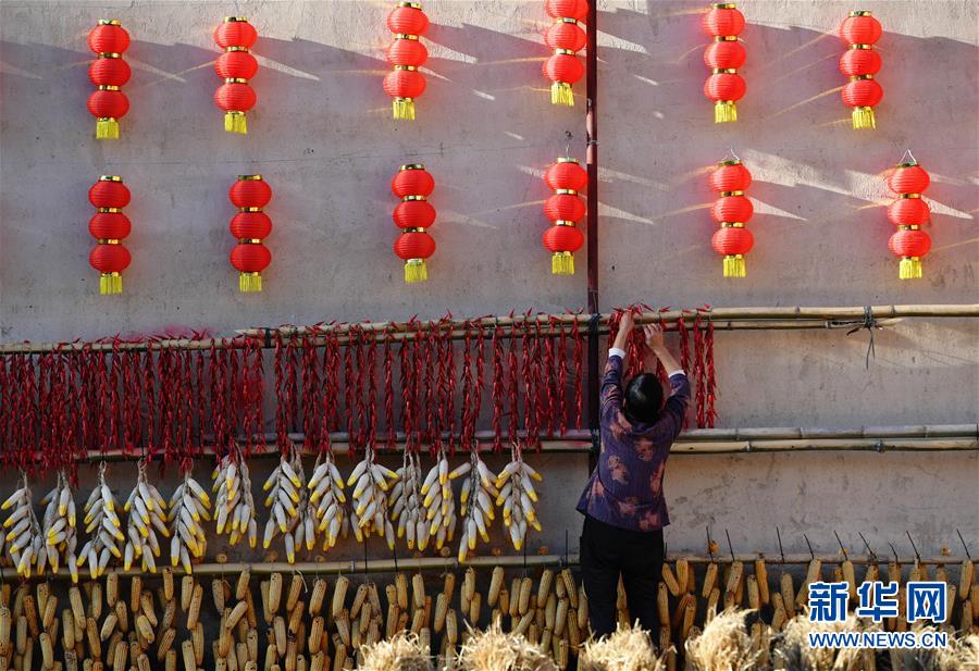 11月1日，一名村民在整理曬架上的農(nóng)作物。 深秋時節(jié)，位于福建省三明市尤溪縣洋中鎮(zhèn)的桂峰村，古民居與曬匾里五彩繽紛的農(nóng)作物，構(gòu)成五彩斑斕的調(diào)色板，展現(xiàn)秋收風情。 新華社記者魏培全攝
